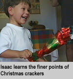 [Isaac learns the finer points of Christmas crackers]