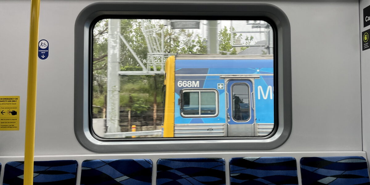 View of a Comeng train from inside an Evolution HCMT train